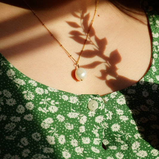 gold filled baroque pearl necklace with satellite chain worn with green floral dress